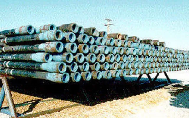 Stacked joints of oilfield pipe with thread protectors on a pipe rack