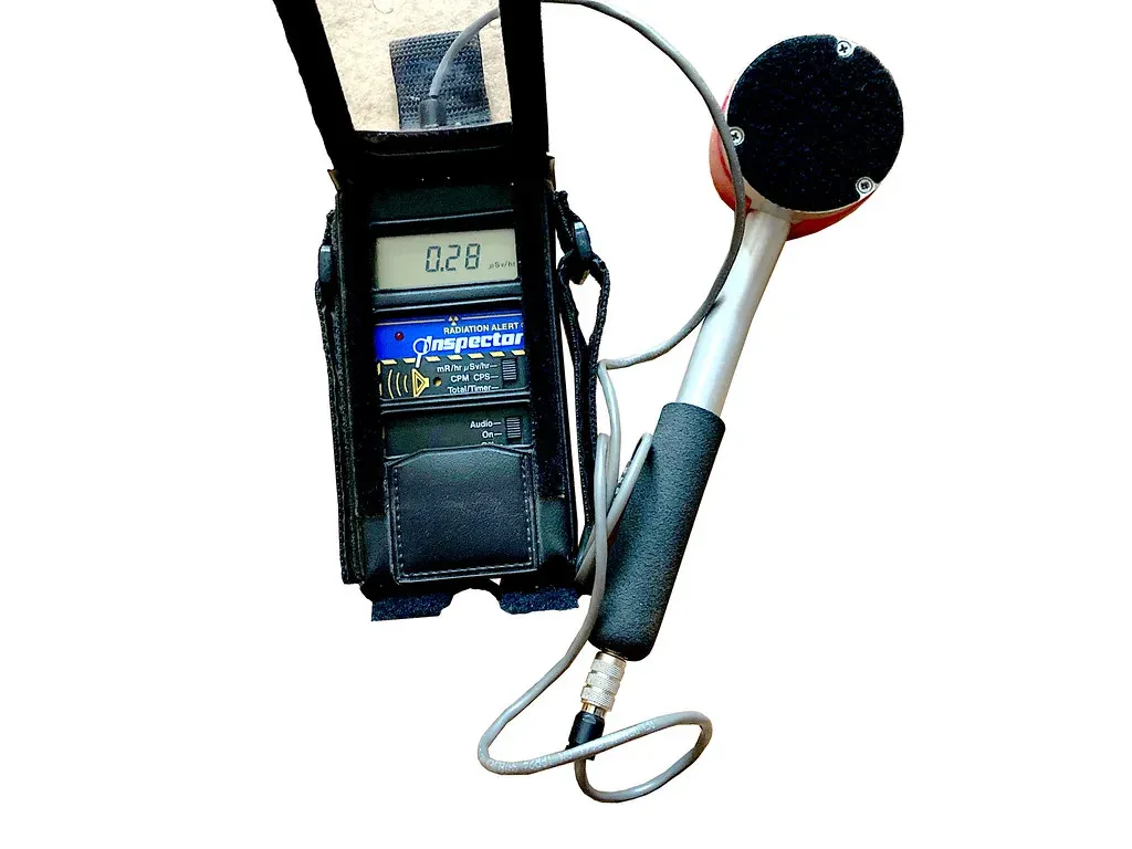Handheld radiation survey meter with a pancake probe, the kind of instrument used for a NORM survey of naturally occurring radioactive material on oilfield equipment