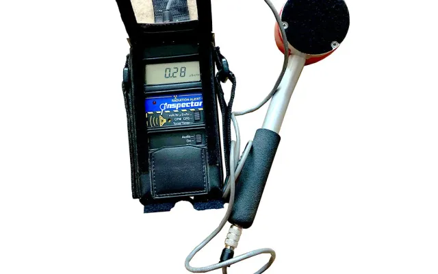 Handheld radiation survey meter with a pancake probe, the kind of instrument used for a NORM survey of naturally occurring radioactive material on oilfield equipment