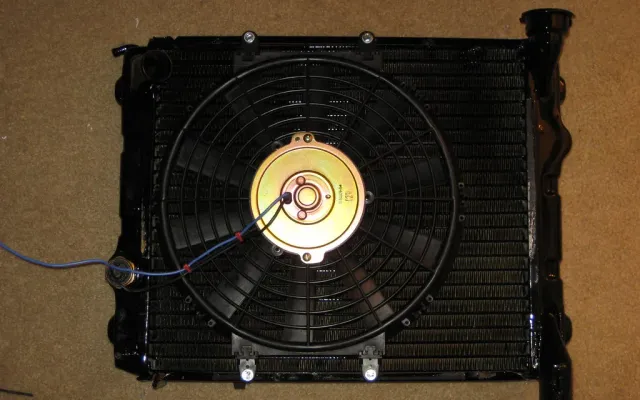 Radiator core with rows of thin fins between the tubes and an electric fan mounted on the back