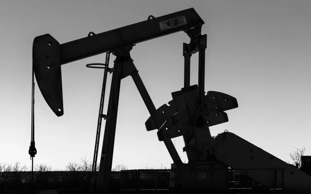 Black and white silhouette of a rod pump pumpjack in West Texas with the horsehead, bridle and polished rod visible