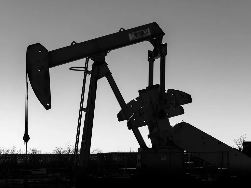 Black and white silhouette of a rod pump pumpjack in West Texas with the horsehead, bridle and polished rod visible