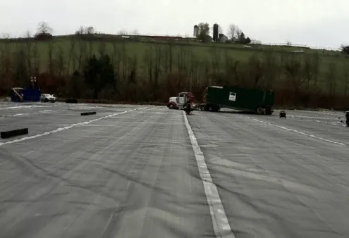 Lined containment pad with a roll-off truck at the far edge