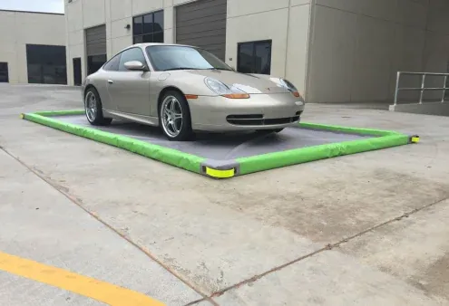Fast Mat drive-over containment berm under a parked car