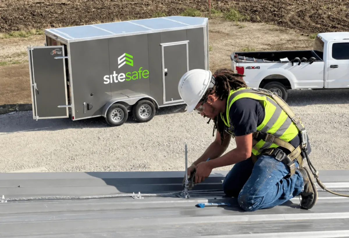 Site Safe technician installing lightning protection on a roof